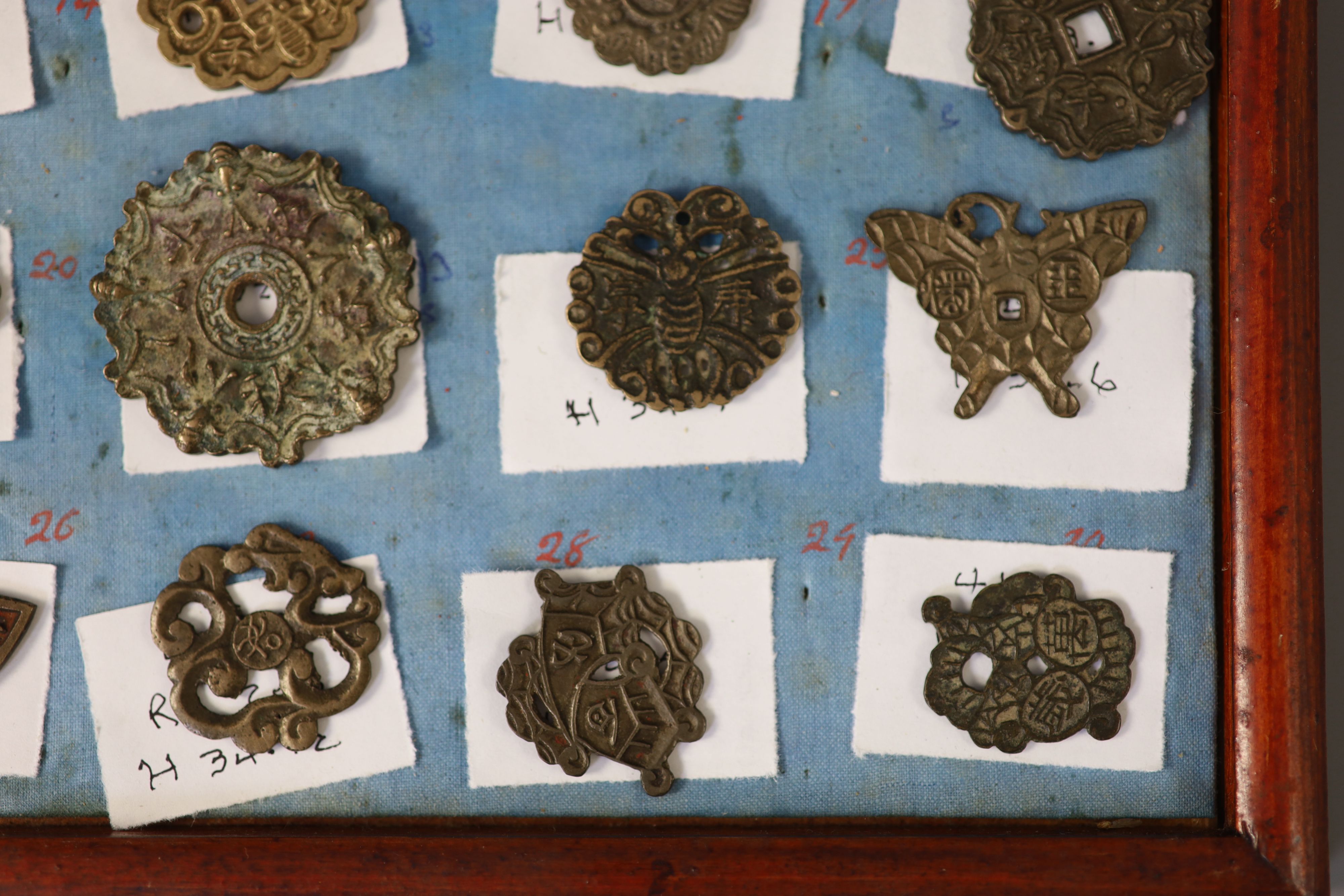 A group of 99 Korean bronze and metal amulets or charms, 19th/20th century